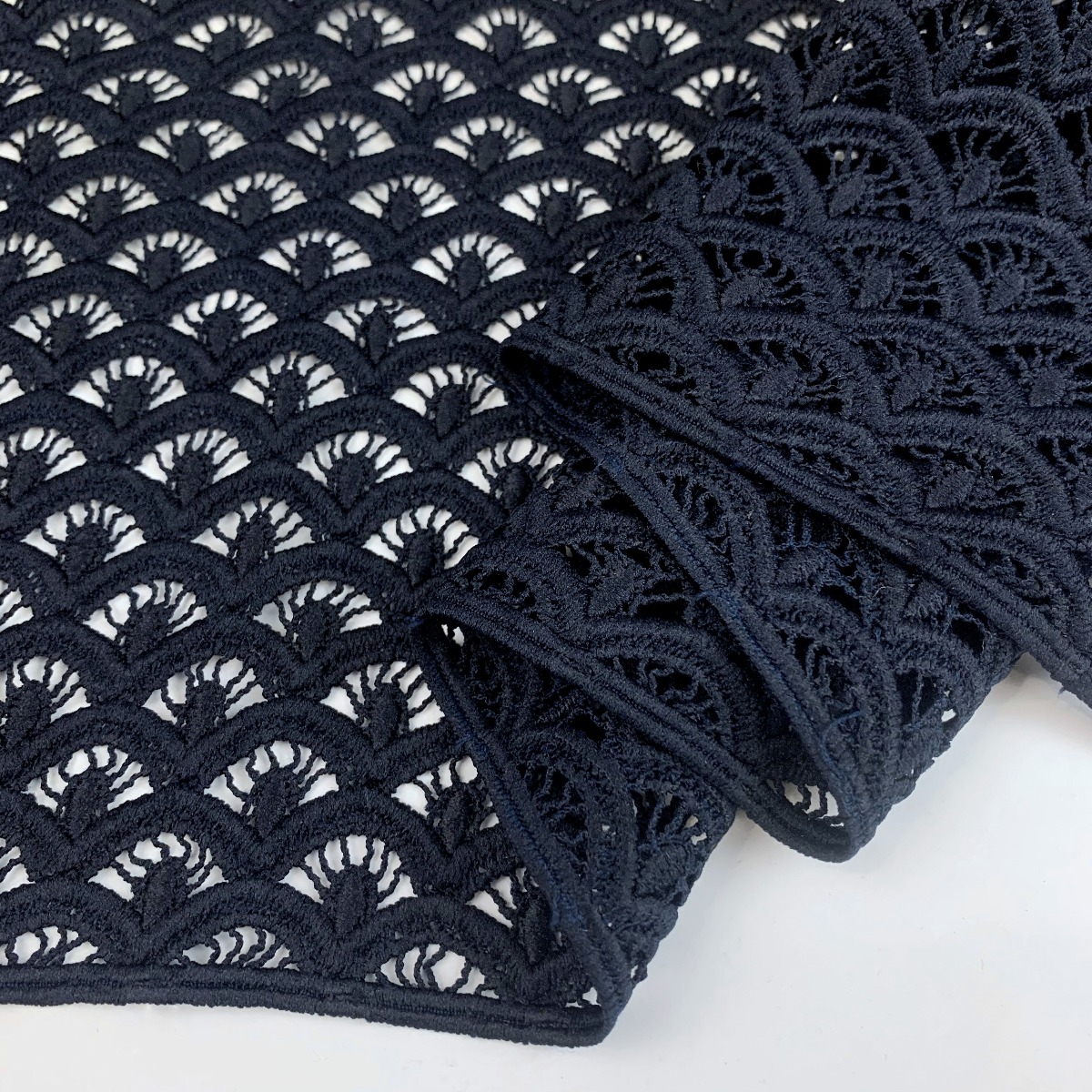 https://www.croftmill.co.uk/images/pictures/2-2021/08-august-2021-2/hope-dark-navy-geometric-guipure-lace-fabric-for-special-occasions-fold-2.jpg?v=7de6720a